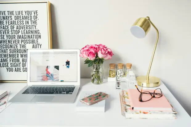macbook-air-beside-gold-colored-study-lamp-and-spiral-books