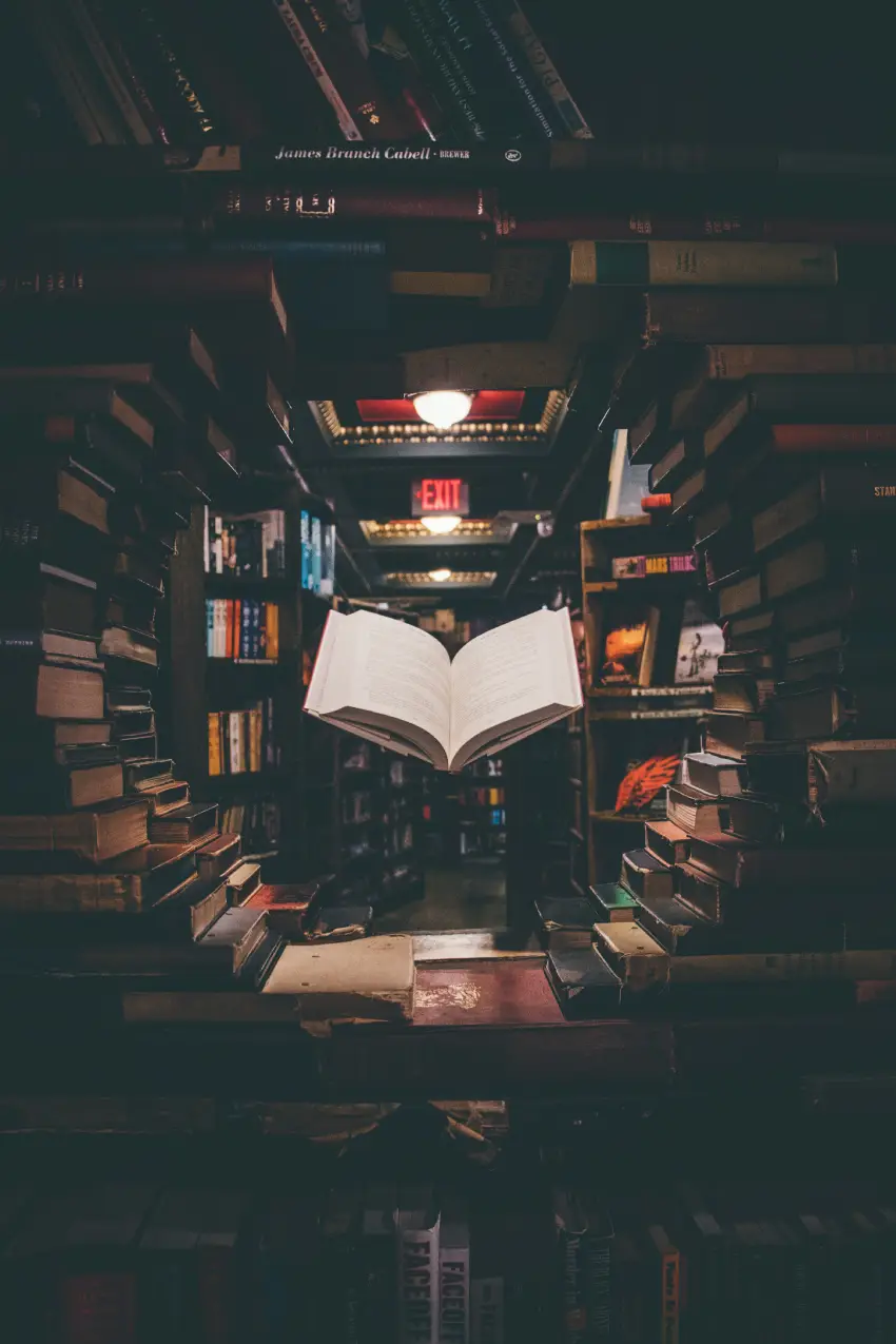 view-of-floating-open-book-from-stacked-books-in-library